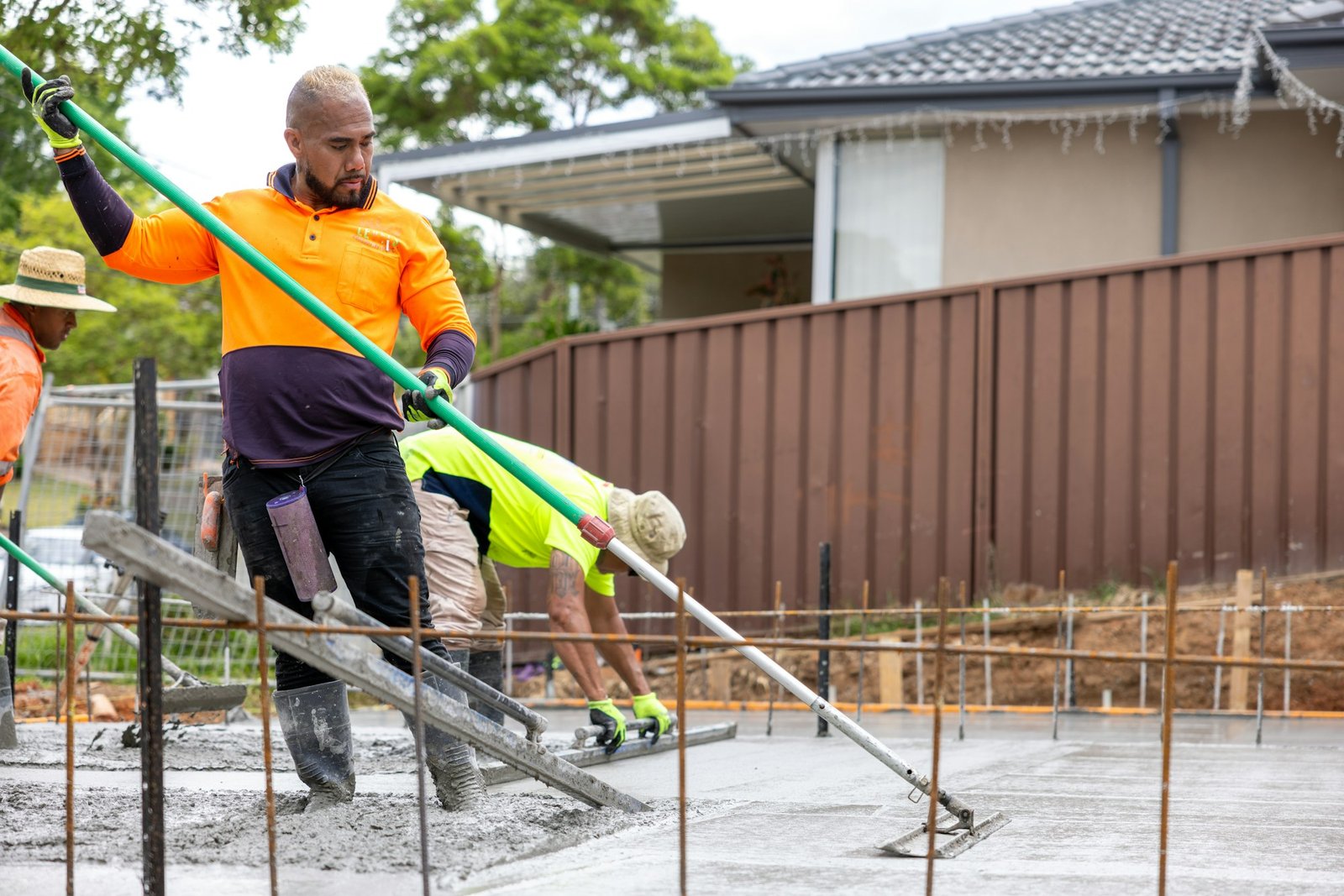 Concrete crew placing and finishing a residential concrete slab